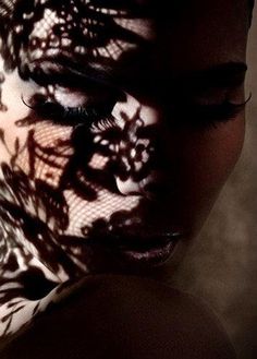 a woman's face is shown with shadows on her body and the image of flowers