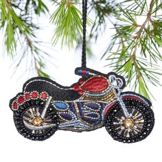 a christmas ornament hanging from a tree with a motorcycle design on the front