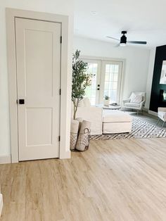 a living room with hardwood floors and white furniture on the floor is pictured in this image