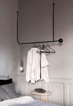 a bedroom with clothes hanging on a rail