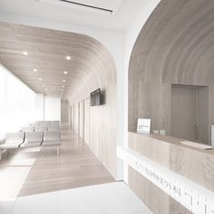 an empty waiting room with white chairs and wood paneling on the walls is shown