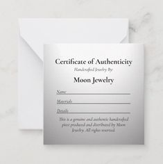 an award certificate for moon jewelry on a marble surface with a white envelope in the background