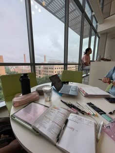 two people sitting at a table with open notebooks and papers on top of it