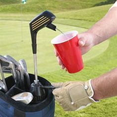 a man holding a red cup filled with golf clubs