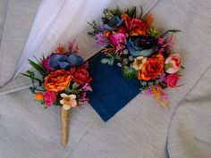 two boutonnieres with colorful flowers are on the lapel cover for an outdoor wedding