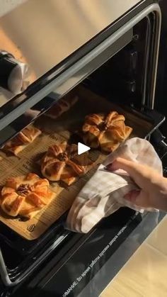 a person pulling out some food from an oven