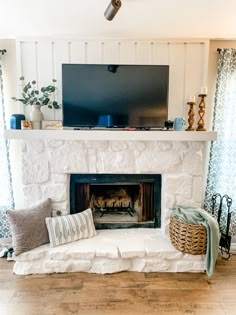 a living room with a fire place and a flat screen tv mounted above it's mantle