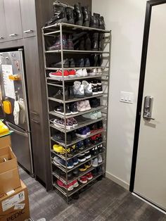 a room filled with lots of shoes and boxes next to a refrigerator in the corner