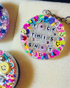 two key chains with buttons and letters on them