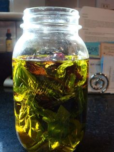 a jar filled with water and leaves on top of a table