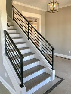 the stairs in this house are painted white and have black railings on each handrail