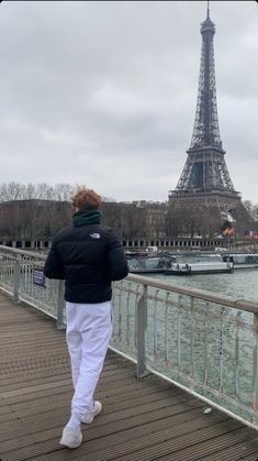 a person walking across a bridge near the eiffel tower