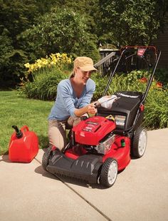 a woman sitting on the ground with a lawn mower