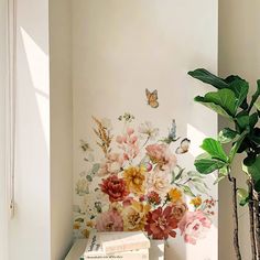 a vase filled with flowers on top of a table next to a book and plant