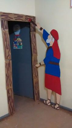 a cardboard cut out of a man in a red and blue outfit opening a door