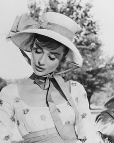 black and white photograph of a woman wearing a hat with her hands on her hips