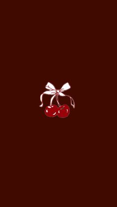 two cherries are tied with a bow on a dark background, one is red and the other is white