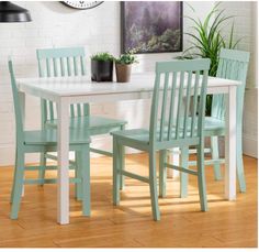 a white table with four chairs and a clock on the wall