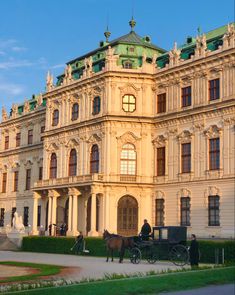 a horse drawn carriage parked in front of a large building