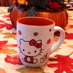 a hello kitty coffee mug sitting on top of a table