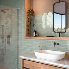 a bathroom sink sitting under a mirror next to a walk in shower