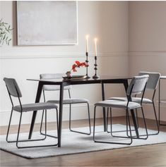 a dining room table with two chairs and a candle on the table next to it