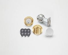 an assortment of door knobs and locks on a white surface