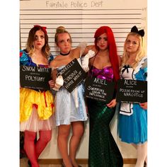 three women dressed as disney characters holding signs