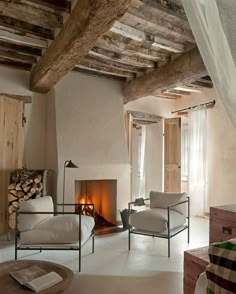 a living room filled with furniture and a fire place next to a window covered in wood