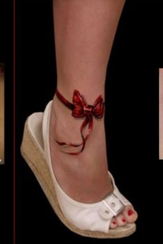 a woman's foot with a red bow on it