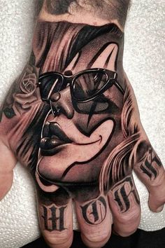 a man's hand with tattoos and glasses on it