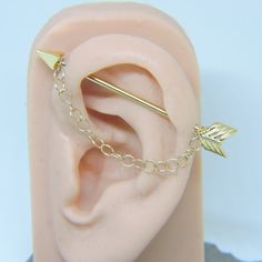 a fake ear with a gold chain and an arrow on the front part of it