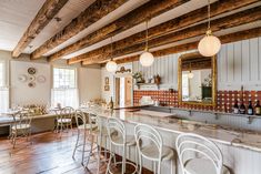 a large kitchen with lots of counter space and bar stools around the center island