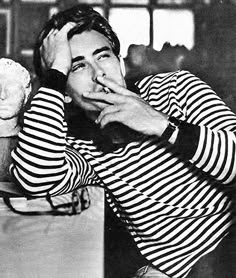 black and white photograph of a woman leaning on a table eating an ice cream cone