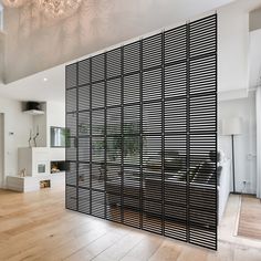 a room divider in the middle of a wooden floor with a chandelier above it