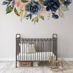 a baby crib in front of a floral wall mural