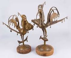 two metal sculptures sitting on top of wooden bases