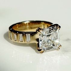 an engagement ring with a princess cut diamond in the center and baguettes on each side