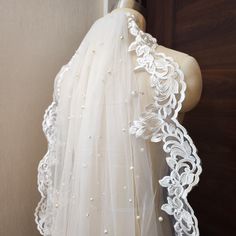 the back of a white veil with flowers on it