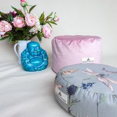 two pillows and a vase with flowers in it