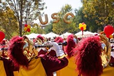 a group of people that are standing in front of some marching equipment with balloons on them