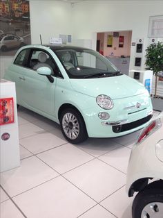 a small light blue car in a showroom