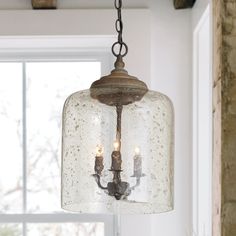 a light fixture hanging from the ceiling in a room with white walls and wooden beams