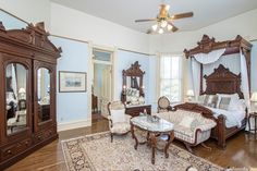 an image of a bedroom with furniture and mirrors on the wall, including a bed