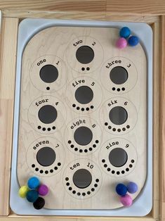 a wooden board with several different types of pom poms on the top and bottom