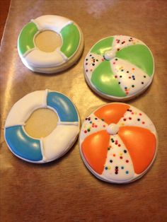 four decorated donuts sitting on top of a wooden table