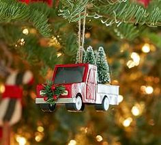 a red truck ornament hanging from a christmas tree