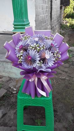 a bouquet of purple flowers sitting on top of a green box