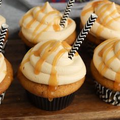 several cupcakes with white frosting and caramel drizzle on top