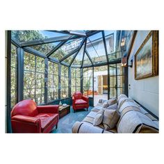 a living room filled with lots of furniture under a large glass ceiling covered in windows